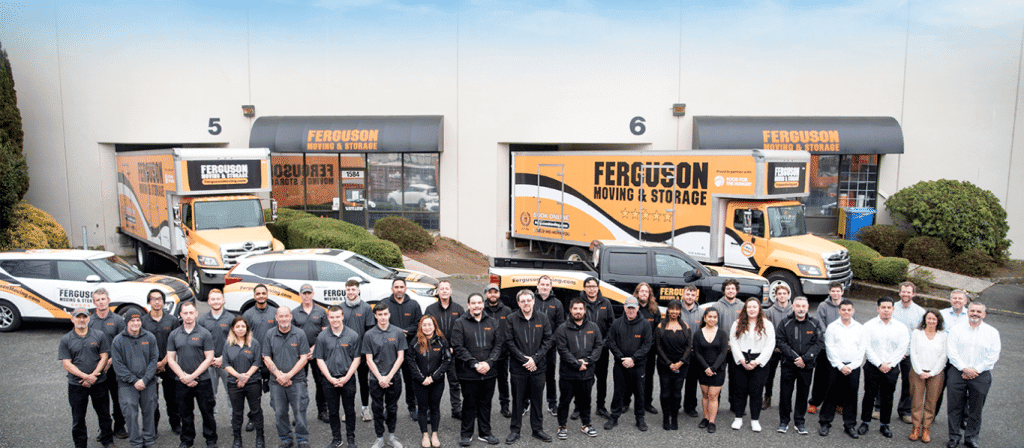 Ferguson Moving & Storage team members standing together in front of the company warehouse.