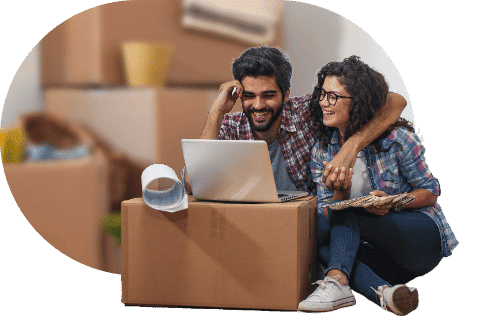 Couple planning their move using a laptop placed on a moving box.