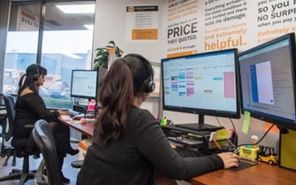 Team sitting in front of computers coordinating logistics for moving services.