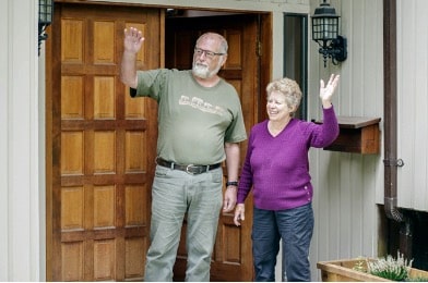 Elderly couple waving goodbye after a moving consultation.