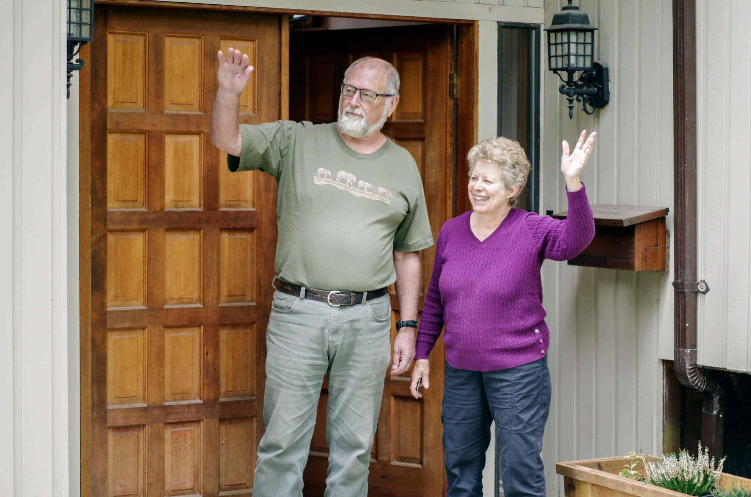 Elderly couple waving goodbye after a moving consultation.