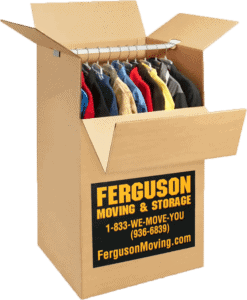 Clothes packed neatly inside a large wardrobe box during the packing process.